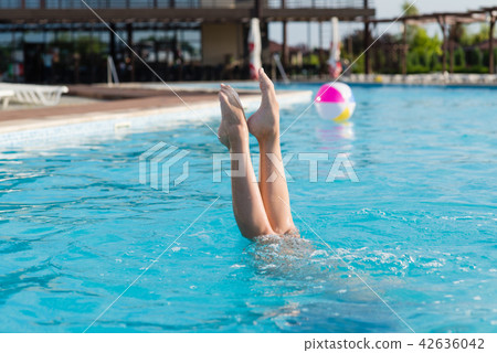 Beautiful female legs stick out of water Beautiful female legs stick out of water 42636042