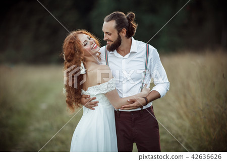 Happy lovely couple bride and groom are walking in the field, wedding and adventure concept Happy lovely couple bride and groom are walking in the field, wedding and adventure concept 42636626
