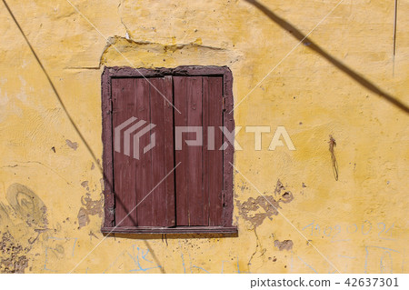Window of an old house with a closed shutter 42637301