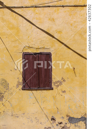 Window of an old house with a closed shutter 42637302