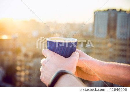 Close up man's hands holding take away paper cup with morning hot drink - coffee or tea with 42646906