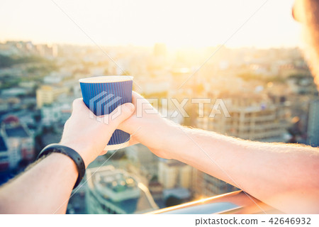 Close up man's hands holding take away paper cup with morning hot drink - coffee or tea with 42646932