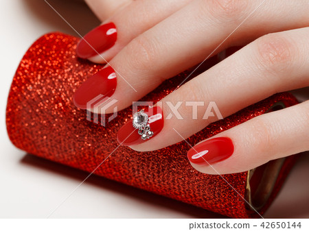 Bright festive red manicure on female hands. Nails design Bright festive red manicure on female hands. Nails design 42650144