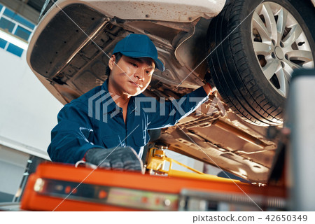 Mechanic inspecting car 42650349
