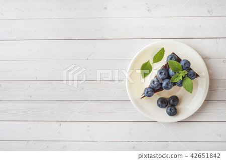 Cake of a souffle with glaze and fresh blueberries Cake of a souffle with glaze and fresh blueberries 42651842
