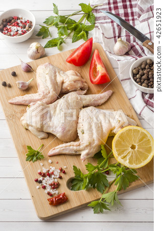 Raw chicken wings in marinade with sauce, pepper  42651923