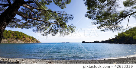 Calm bay and pebbly deserted beach with shadow  42653339
