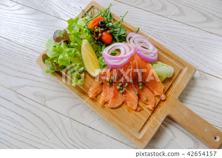 Smoked salmon salad is arranged beautifully.  42654157