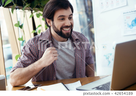 Man sitting at the table at creative stylish office looking at s 42654189