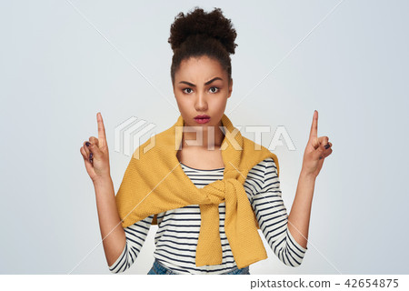 Young woman studio isolated in white pointing up with two hands  42654875
