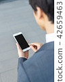 A businessman operating a smartphone 42659463