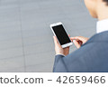 A businessman operating a smartphone 42659466