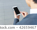 A businessman operating a smartphone 42659467