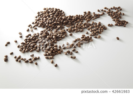 roasted coffee beans poured from clear glass 42661983