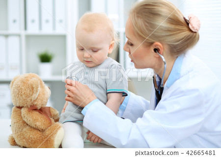 Doctor and patient in hospital. Little girl is being examined by pediatrician with stethoscope Doctor and patient in hospital. Little girl is being examined by pediatrician with stethoscope 42665481