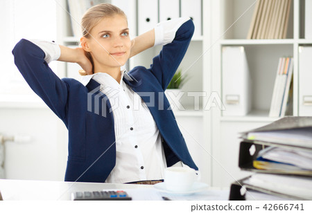 Happy business woman or female accountant having some minutes for coffee and pleasure at working 42666741