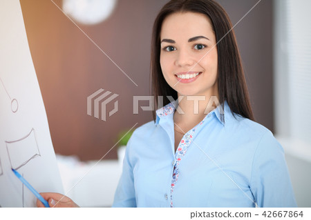 Young brunette business woman looks like a student girl working in office. Hispanic or latin 42667864