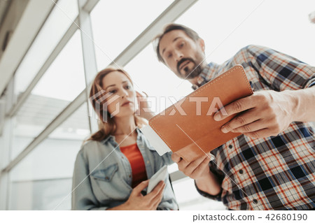 Calm man and girl looking at tickets 42680190