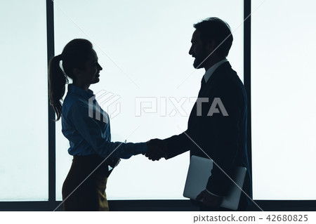 Cheerful woman shaking male hand 42680825