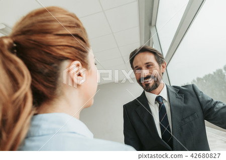 Pleased male speaking with girl during job 42680827