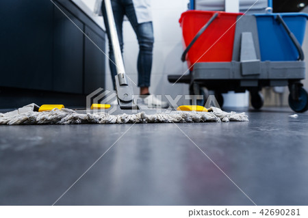 Low shot of cleaning lady mopping the floor in restroom 42690281