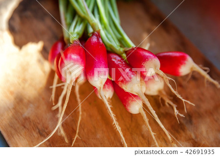 Large bunch of raw fresh juicy garden radish on wooden board Large bunch of raw fresh juicy garden radish on wooden board 42691935