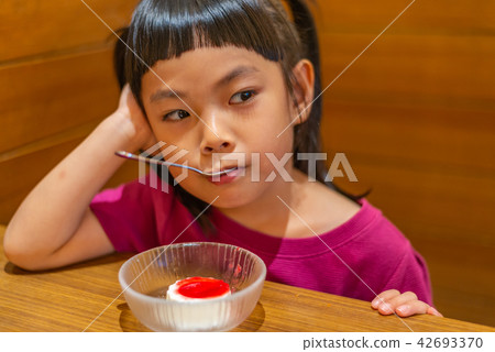 Asian little girl eating dessert Asian little girl eating dessert 42693370