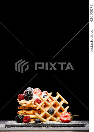 Photo of viennese wafers with fresh raspberries, strawberries sprinkled with powdered sugar on Photo of viennese wafers with fresh raspberries, strawberries sprinkled with powdered sugar on 42695078