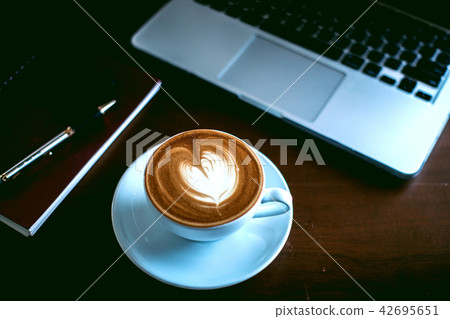 A gass of coffee and laptop on the desktop. A gass of coffee and laptop on the desktop. 42695651