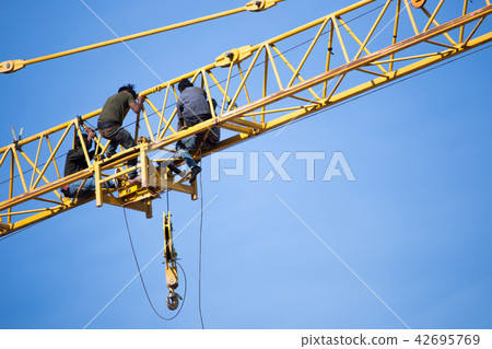 Group of labour working on the tower crane. 42695769