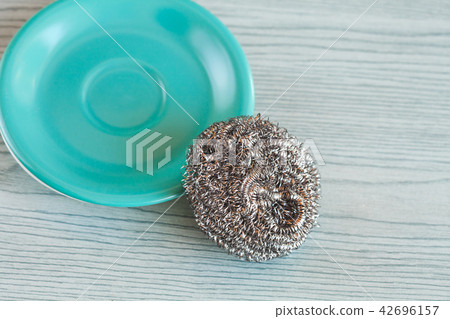 Steel wool with dish on wood table ,cleanning Steel wool with dish on wood table ,cleanning 42696157