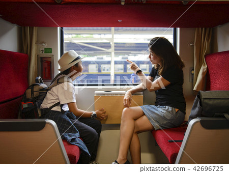 Mother and son looking through a train window as t Mother and son looking through a train window as t 42696725