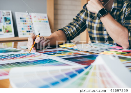 Young creative Graphic designer using graphics tablet to choosin Young creative Graphic designer using graphics tablet to choosin 42697269