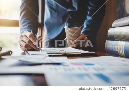 Businessman pointing at graph and chart to analysis use for plan Businessman pointing at graph and chart to analysis use for plan 42697275