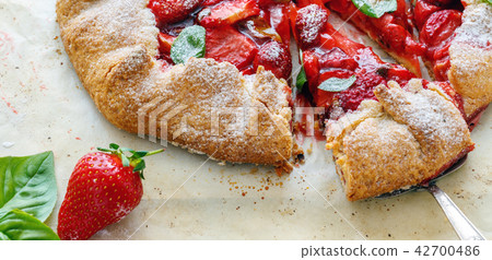 Cut homemade cake with strawberries and basil. Cut homemade cake with strawberries and basil. 42700486