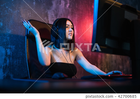 A girl, is holding a smartphone and is frustrated with shouts. On a black background. A girl, is holding a smartphone and is frustrated with shouts. On a black background. 42700685