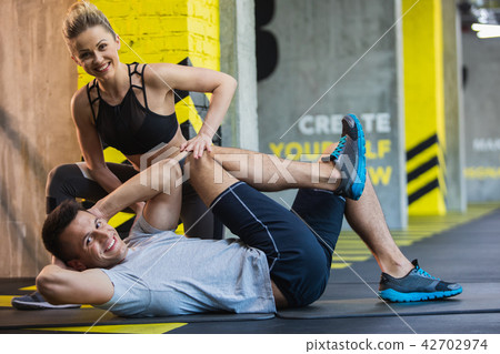 Joyful man is exercising with female coach indoors 42702974