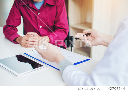 Doctors and patients sit and talk. At the table Doctors and patients sit and talk. At the table 42707644