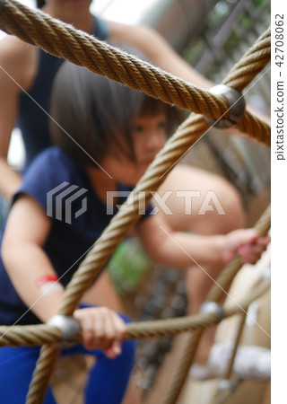 Asian Chinese Child attempting rope obstacle cours 42708062