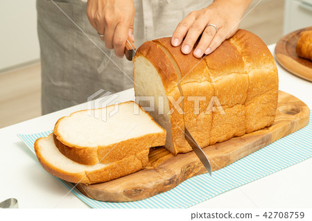 Hand cutting bread 42708759