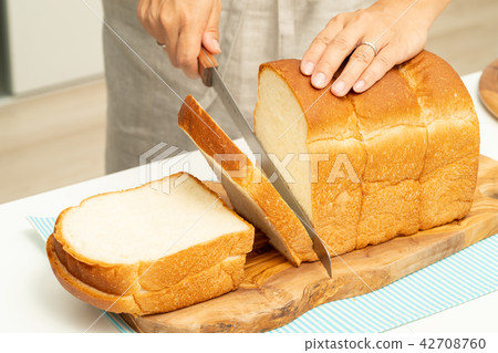 Hand cutting bread 42708760