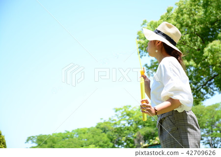 A woman blowing a bubble ball A woman blowing a bubble ball 42709626