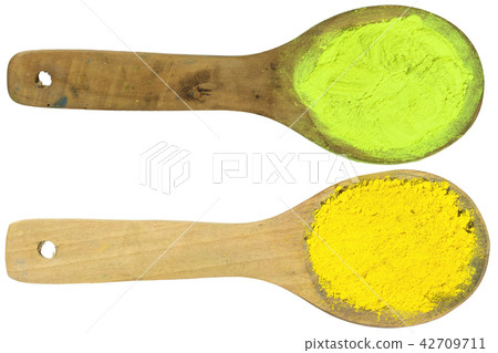 yellow powder on wooden spoons with clipping path 42709711