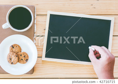 Man writes on a blackboard and cup of coffee Man writes on a blackboard and cup of coffee 42710715