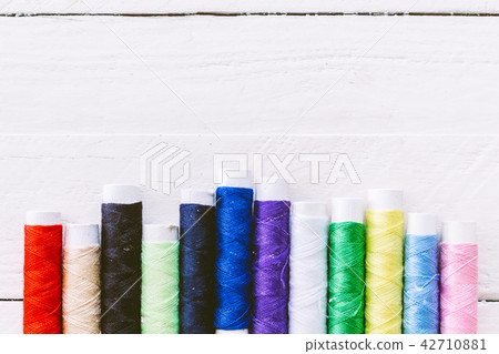 Colorful threads on wooden table Colorful threads on wooden table 42710881