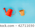 Watering can on blue background 42711030