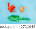 Watering can on blue background 42711049