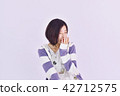 A woman waking up with a hand on her face 42712575