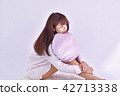A woman in a pajamas with a cushion 42713338