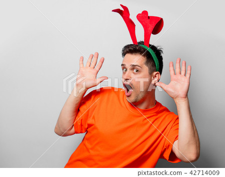 man in orange t-shirt with Christmas deer horns 42714009